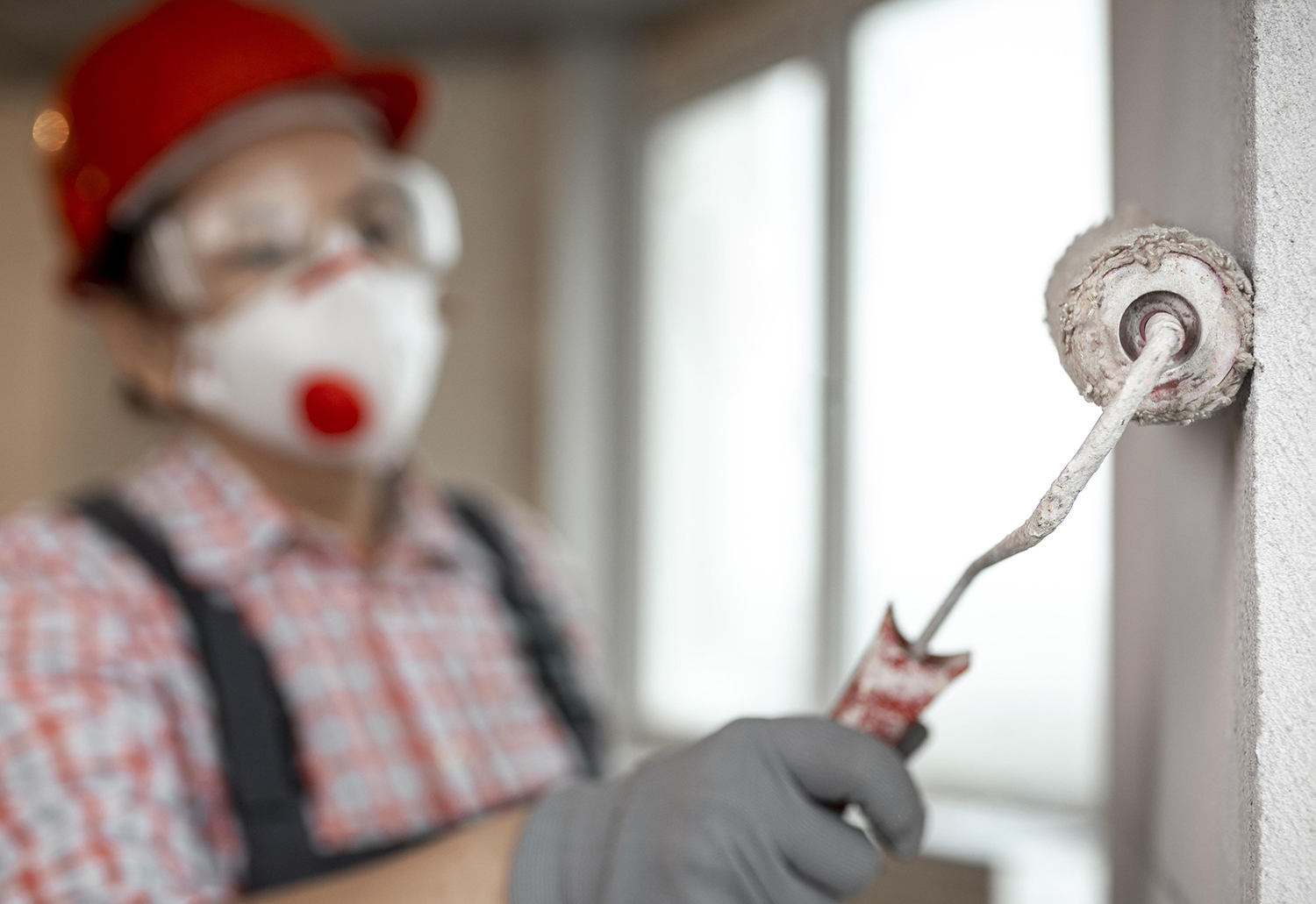 trabajador de la construccion femenina con casco y rodillo de pintura